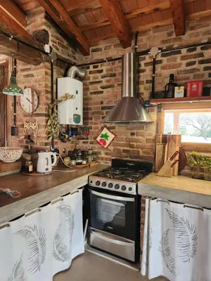 a kitchen with a stove top oven next to a counter at Descanso Serrano in Las Rabonas