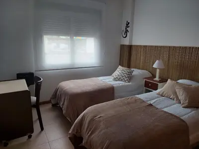 a hotel room with two beds and a window at Costanera in Río Cuarto