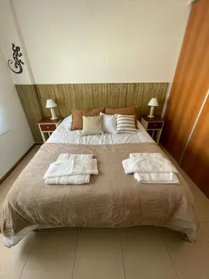 a bedroom with a large bed with towels on it at Costanera in Río Cuarto