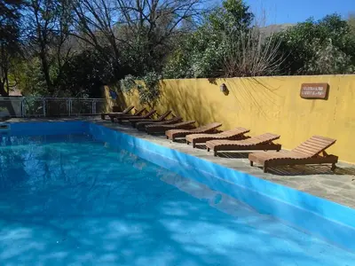 a pool with chaise lounge chairs and a swimming pool at Hostería de los Césares in Merlo