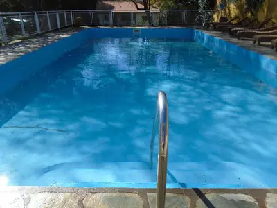 a blue swimming pool with a metal pole in it at Hostería de los Césares in Merlo
