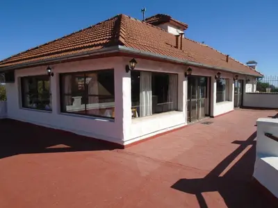 a house with a lot of windows on a patio at Hostería de los Césares in Merlo