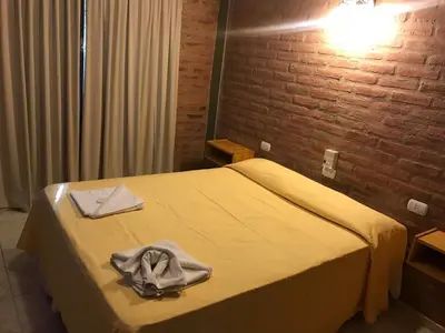 a hotel room with a bed with towels on it at Terrazas del Diquecito in Villa Carlos Paz