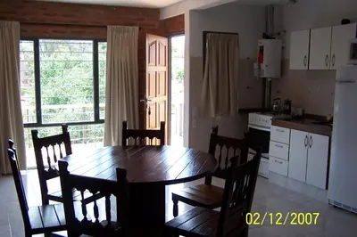 a kitchen with a wooden table and chairs in a room at Terrazas del Diquecito in Villa Carlos Paz
