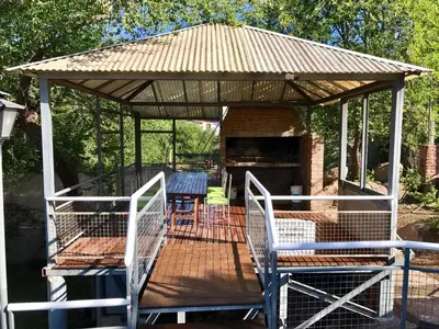 a gazebo with two chairs and a table at Terrazas del Diquecito in Villa Carlos Paz