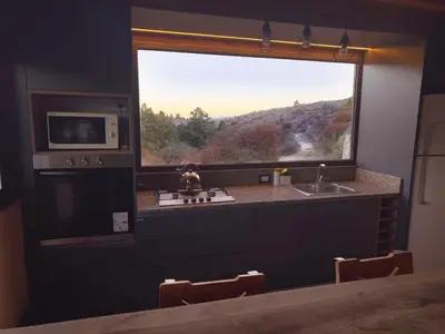 a kitchen with a window and a sink and a stove at Cuesta de las Piedras in La Cumbrecita