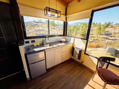 a kitchen with a large window with a view of a mountain at Cuesta de las Piedras in La Cumbrecita
