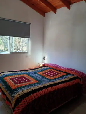 a bedroom with a bed with a colorful blanket on it at La Porteña in Cortaderas