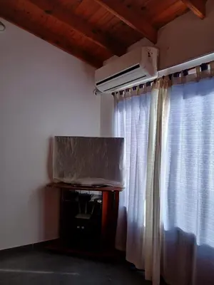 a room with a window with curtains and a projector at La Porteña in Cortaderas