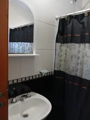 a bathroom with a sink and a shower curtain at La Porteña in Cortaderas