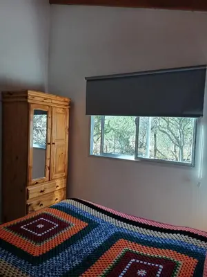 a bedroom with a bed with a dresser and a window at La Porteña in Cortaderas