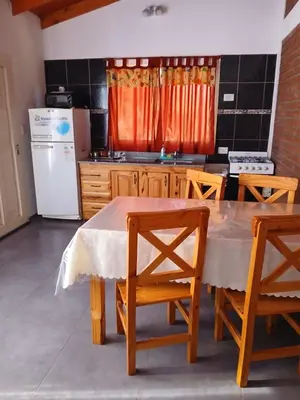 a kitchen with a table and chairs and a refrigerator at La Porteña in Cortaderas