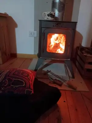a stove in a room with a fire in it at Kururu Cabaña en Villa Yacanto con vista a las sierras in Villa Yacanto