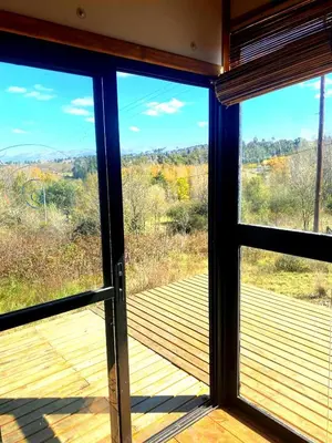 a view from a window of a deck at Kururu Cabaña en Villa Yacanto con vista a las sierras in Villa Yacanto