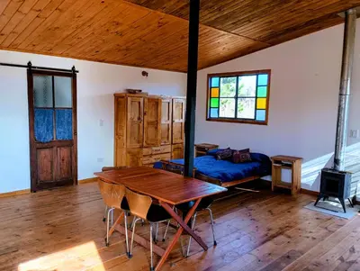 a living room with a table and a couch at Kururu Cabaña en Villa Yacanto con vista a las sierras in Villa Yacanto