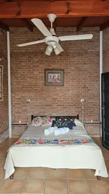 a bed in a room with a ceiling fan at Casa Cian in Mina Clavero
