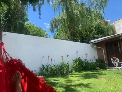 a person laying in a hammock in front of a white fence at Casa Cian in Mina Clavero