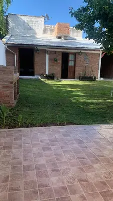 a brick house with a grass yard and a brick driveway at Casa Cian in Mina Clavero