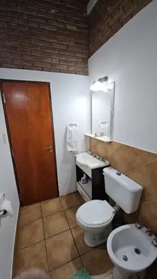 a bathroom with a toilet and a sink and a mirror at Casa Cian in Mina Clavero