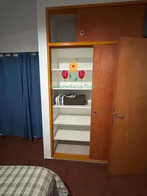 a cabinet in a room with a bed at Apartamentos Las Flores in Villa Carlos Paz