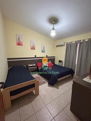 a bedroom with a bed with flowers on it at Apartamentos Las Flores in Villa Carlos Paz
