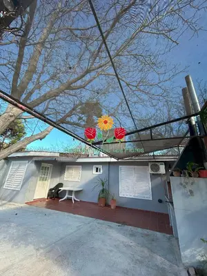 a house with two red flowers on top of it at Apartamentos Las Flores in Villa Carlos Paz