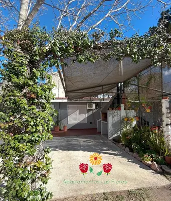 a house with a garden with flowers on it at Apartamentos Las Flores in Villa Carlos Paz