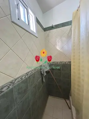 a shower with a flower on the wall in a bathroom at Apartamentos Las Flores in Villa Carlos Paz