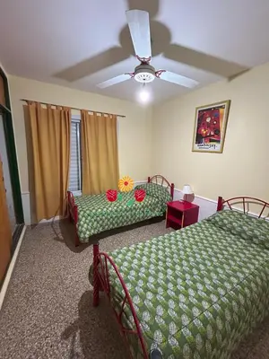 a bedroom with two beds and a ceiling fan at Apartamentos Las Flores in Villa Carlos Paz