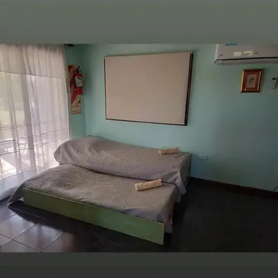 two beds in a room with a whiteboard on the wall at Suite's on the rock's in Nono