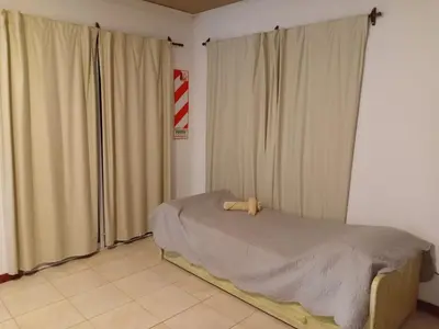 a bedroom with a bed and two large windows at Suite's on the rock's in Nono