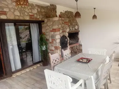a dining room with a table and a stone fireplace at Suite's on the rock's in Nono