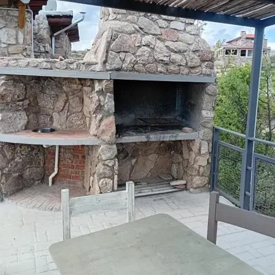 an outdoor stone oven with a table and a bench at Suite's on the rock's in Nono
