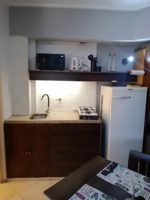 a small kitchen with a sink and a refrigerator at Departamento con hermosa vista en Carlos Paz in La Cuesta
