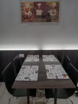 a wooden table with chairs and a picture on the wall at Departamento con hermosa vista en Carlos Paz in La Cuesta