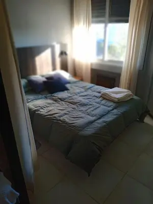 a bed sitting in a room with a window at Departamento con hermosa vista en Carlos Paz in La Cuesta