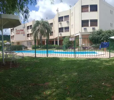 a fence around a pool in front of a building at Departamento con hermosa vista en Carlos Paz in La Cuesta