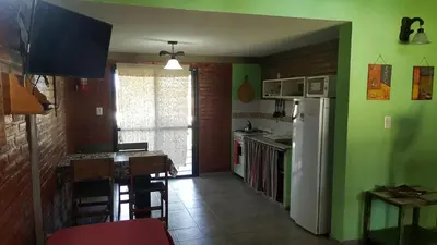 a kitchen with green walls and a white refrigerator at Complejo Lago Serrano in Villa Rumipal