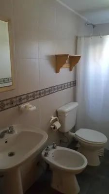 a bathroom with a toilet and a sink at Complejo Lago Serrano in Villa Rumipal