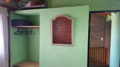 a room with a green wall with a window at Complejo Lago Serrano in Villa Rumipal