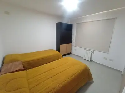 a bedroom with a yellow bed and a large screen at Confortable Casa en Pilar Rio II in Pilar