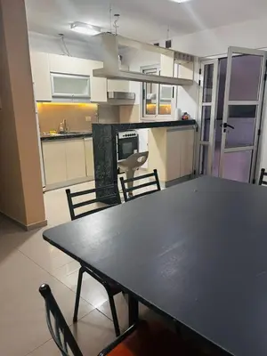 a table and chairs in a room with a kitchen at Confortable Casa en Pilar Rio II in Pilar