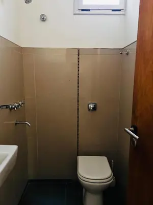 a bathroom with a toilet and a sink and a window at Confortable Casa en Pilar Rio II in Pilar