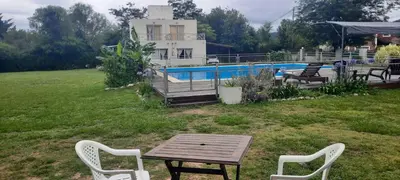 a table and chairs in a yard with a pool at Cabañas Las Luceros in San Antonio de Arredondo