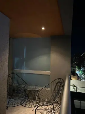 two chairs and a table on a balcony at night at Miradores del buen pastor - Nueva cordoba in Cordoba