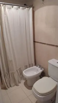 a bathroom with a toilet and a shower curtain at Departamento amplio, Zona Nueva Cba , A cien metros de la terminal Buss in Cordoba