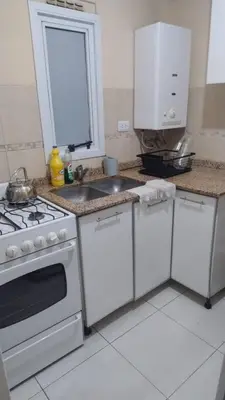 a kitchen with a white stove and a sink at Departamento amplio, Zona Nueva Cba , A cien metros de la terminal Buss in Cordoba
