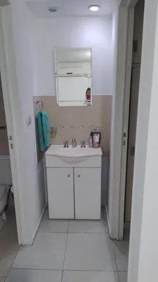 a white bathroom with a sink and a mirror at Departamento amplio, Zona Nueva Cba , A cien metros de la terminal Buss in Cordoba
