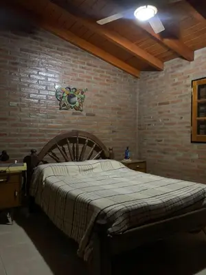 a bedroom with a large bed in a brick wall at Los nonos in Villa Los Aromos