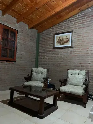 two chairs and a coffee table in front of a brick wall at Los nonos in Villa Los Aromos
